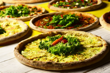 Pizza circles with meat, zucchini, salad and cheese