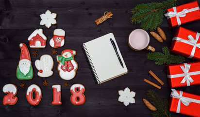 Fototapeta na wymiar Top view of blank notebook on wooden background with xmas decorations, copy space. Christmas background with empty notebook, gingerbread cookies and hot cocoa, red gift boxes. Flat lay