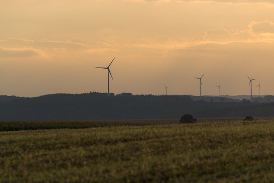 Windpark at sunset generating the power of the future. Representing hope for future generations and fight against global warming in Europe. Hosingen, Luxembourg