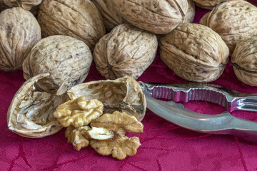 Noix en vrac sur nappe rouge et casse noix avec noix cassée
