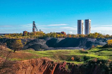 Landscape with two mine head frames . Ukraine, Kryvyi Rih, Iron-ore mine Gvardeiskaya. An autumn sunny day with blue sky. Mining Production