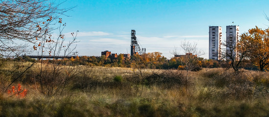 Landscape background with two mine head frames . Ukraine, Kryvyi Rih, Iron-ore mine Gvardeiskaya. An autumn sunny day with blue sky. Mining Production