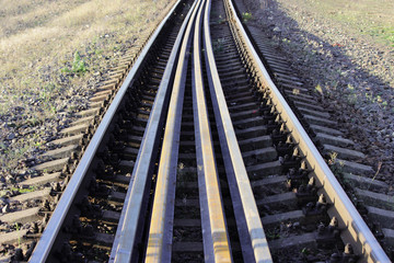 Fototapeta na wymiar Several rails lie on the sleepers between the main rails on the railway. bolts that secure the rails to the sleepers on the railway direction
