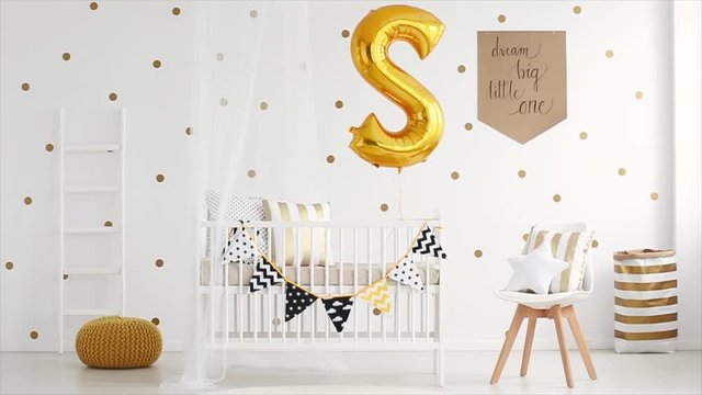 Handmade poster with motivational text hanging on the wall with dots in nursery room