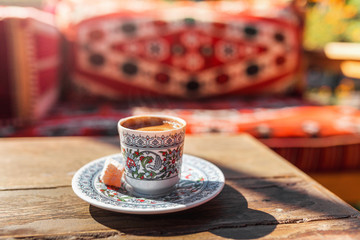 Authentic traditional Turkish coffee in a mug with national patterns on a wooden table in a local...