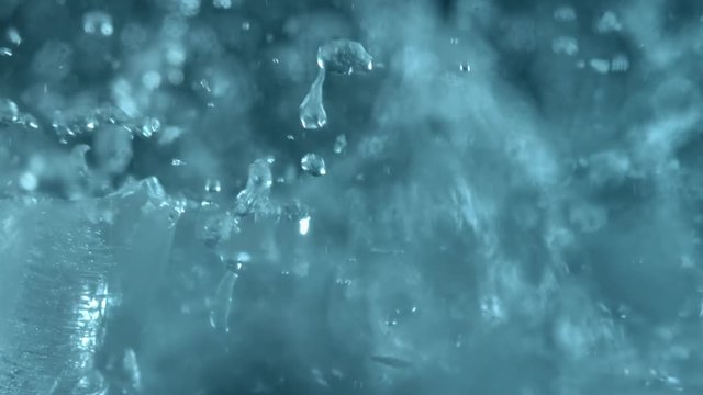 Blue and clean ice breaking in slow motion on black