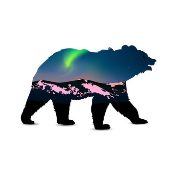 Silhouette of bear with green northern lights above mountains.