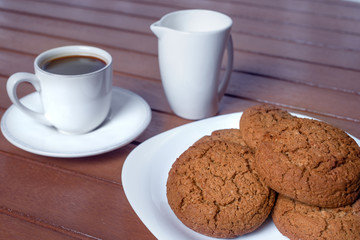 Coffee cup and cookie on wood