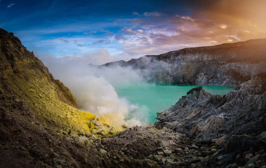 Kawah Ijen volcano with green lake on blue sky background at morning in East Java, Indonesia.