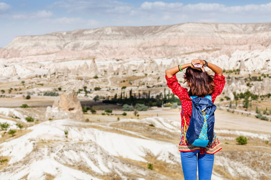 Young happy woman travels alone on beautiful Cappadocia and enjoying great view, Turkey