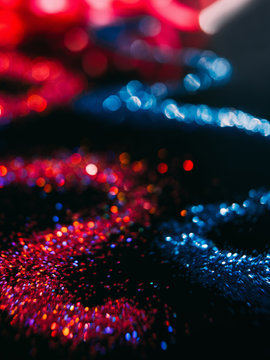 Abstract wavy sparkling glitter on contrast black background. Defocused bokeh concept