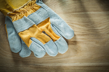 Pair of protective gloves on wooden board