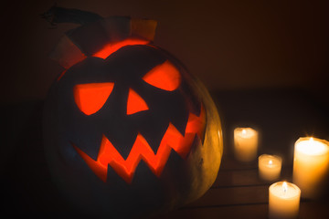 Photo of pumpkin Halloween on a wooden table and wax candles