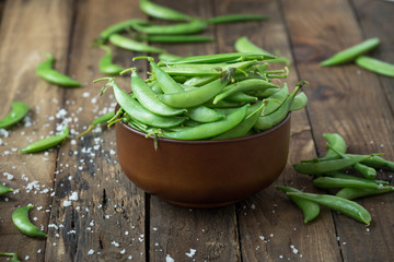 Green pea in bowl on rustic wooden background