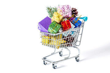 New Year's gifts in a shopping trolley close-up isolated on a white background. A shopping cart full of Christmas gifts isolated on white background.