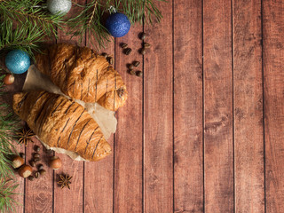 Christmas Breakfast croissant on a napkin. Dark wooden background. Christmas decorations Copy space