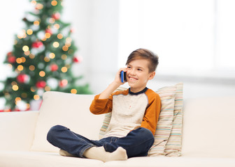 boy calling on smartphone at home at christmas