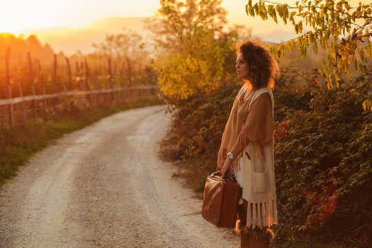 Woman on the contry side road,with suitcase