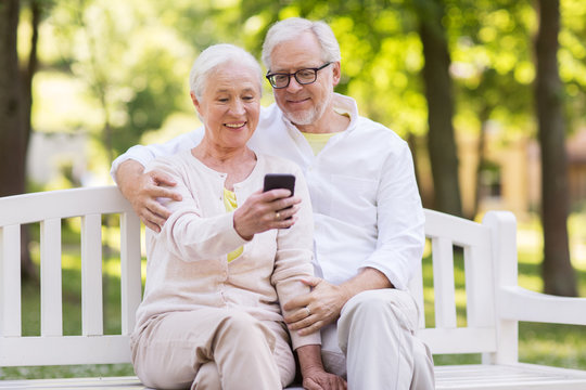 senior couple taking selfie by smartphone at park - Powered by Adobe