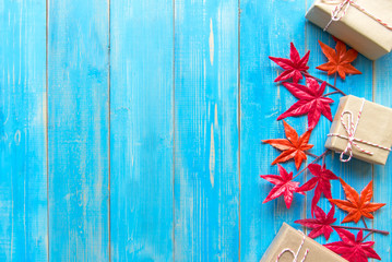 Christmas gift boxes and maple on blue wooden background. Top view with copy space