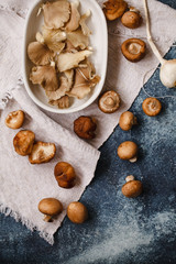 Fresh oyster shiitake mushroom over blue board top view. 