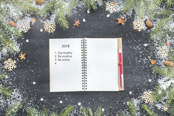 Xmas Wishlist Healthy Lifestyle Goals on Empty Blank Letter Notebook on Black Wooden Table with Christmas Festive Decoration Fir Branches Snow Flat Lay Top View
