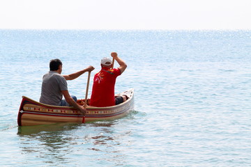 Two man boating in handmade canoes of wooden planks on Black sea