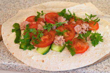Fresh tomatoes with cucumber, salmon in oil and chopped parsley on lavash (pita bread). Fast and tasty food