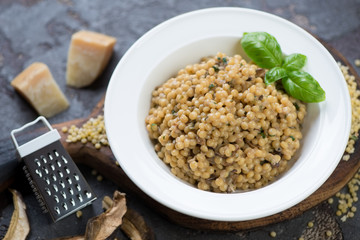 Close-up of pasta with ceps and parmesan cheese served in a white plate, studio shot