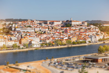 Fototapeta premium Cityscape view on the old town of Coimbra city with Mondego river during the sunny day in the central Portugal