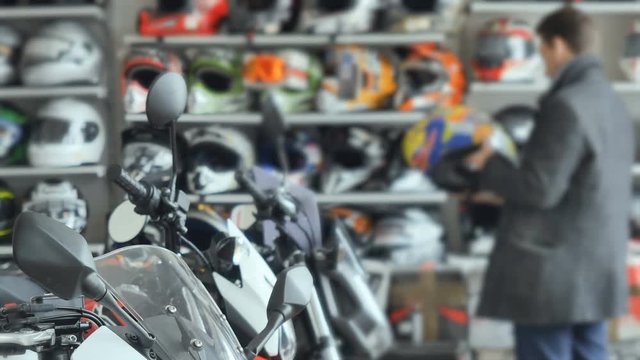 Man choose helmet in motorbike store