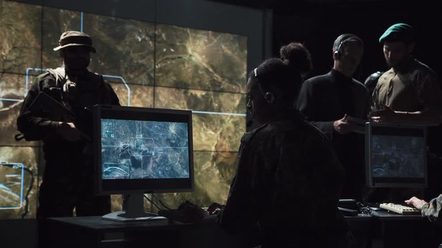 Group of military in operation center controlling and monitoring launch of nuclear missile.