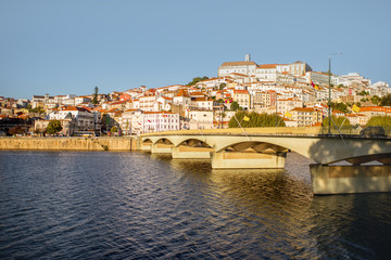 Fototapeta na wymiar Cityscape view on the old town of Coimbra city with Mondego river and bridge during the sunset in the central Portugal
