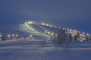 Downhill ski slope in the evening lighting