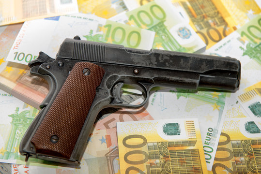 close up image of pistol and euro money