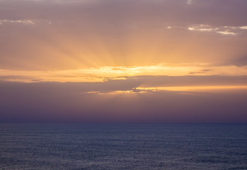 Obraz premium nice sunset with rays of light among the clouds over the sea in Sagres, Algarve, Portugal