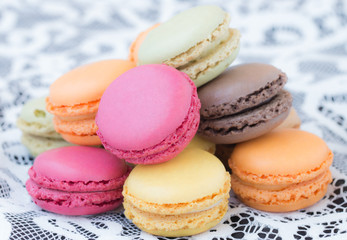 Colorful macaroons on a white lace background.