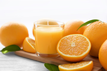 Glass of orange juice with fruit on wooden board