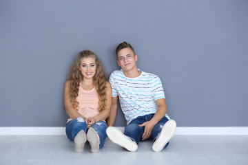 Young couple sitting on floor in room at new home