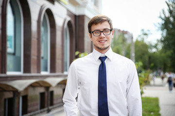 Attractive young man in formal wear on city street