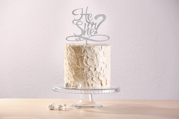 Stand with delicious cake for baby shower party on light background