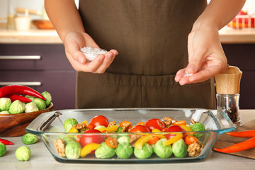 Woman cooking brussels sprouts on table