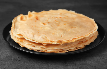 Plate with tasty buckwheat thin pancakes on table