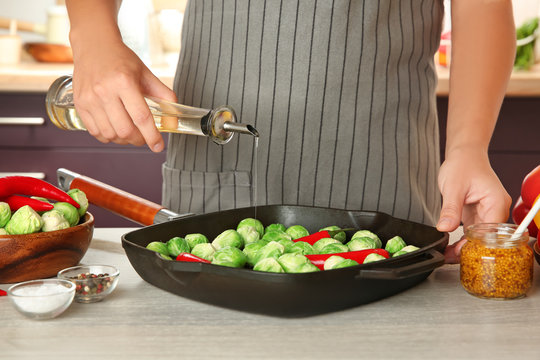 Woman cooking brussels sprouts on table