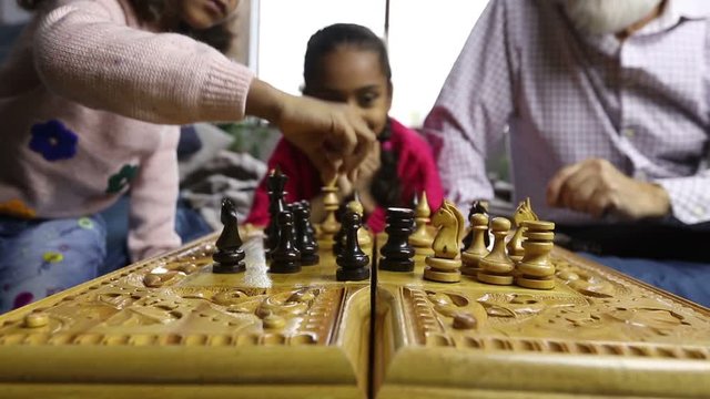 Diverse family playing chess together at home
