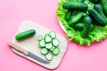 Cut fresh cucumbers. Pink background top view
