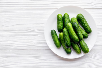 Fresh cucumbers on the palte. Grey wooden background top view copyspace