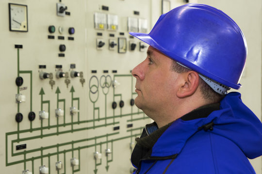Engineer with red  helmet control instruments in power plant
