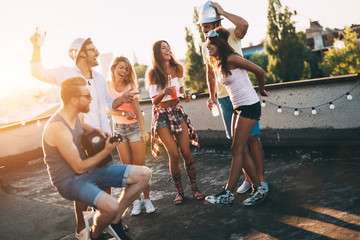 Group of happy friends having party on rooftop - obrazy, fototapety, plakaty