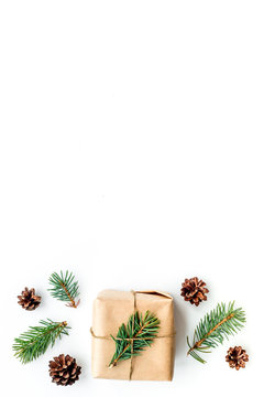 Gifts for new year wrapped in craft paper near spruce branches and cones on white background top view copyspace